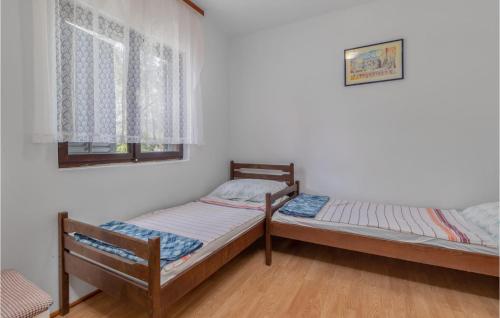 two twin beds in a room with a window at Nice Apartment In Pinezici With Kitchen in Pinezici