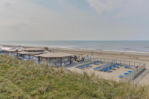a beach with chairs and umbrellas and the ocean at CHALET FOR 2 AT THE BEACH in Zandvoort