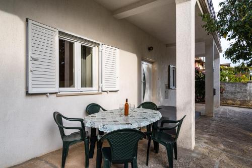 a table and chairs with a table and a window at Apartment Eva in Maslenica