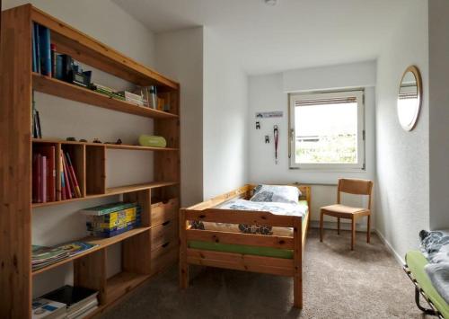 een slaapkamer met een bed en een boekenplank bij FeWo Clemens - Wohnküche + 2 Schlafräume + Bad + Terrasse in Hamm