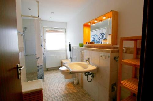 een badkamer met een wastafel, een toilet en een spiegel bij FeWo Clemens - Wohnküche + 2 Schlafräume + Bad + Terrasse in Hamm