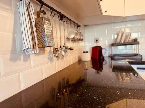 a kitchen with utensils hanging on a wall at Appartement de Luxe -Prestigia Marrakech Golf City in Marrakech