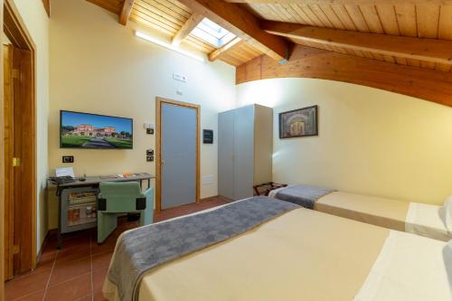 a bedroom with two beds and a desk with a computer at Villa Signorini Hotel in Ercolano