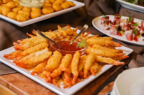 a table with plates of french fries and dipping sauces at Hotel Lago di Braies in Braies