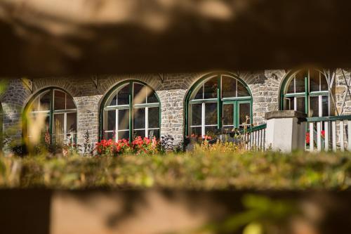 a brick building with windows and flowers in front of it at Hotel Lago di Braies in Braies