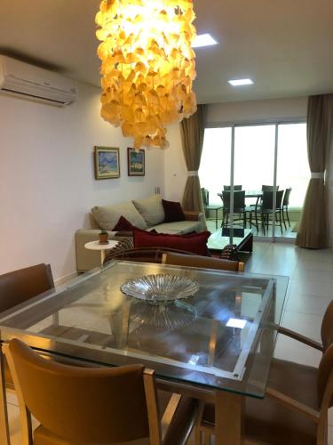 a living room with a glass table with chairs at Apto de luxo no Golfville Ideal para família e home office Prox do Beach Park in Aquiraz