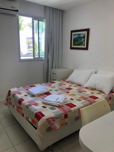 a bedroom with a bed with a quilt on it at Apto de luxo no Golfville Ideal para família e home office Prox do Beach Park in Aquiraz