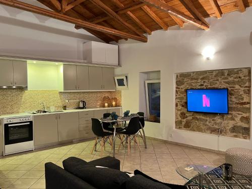 a kitchen with a table and a tv on a wall at Iras in Samos