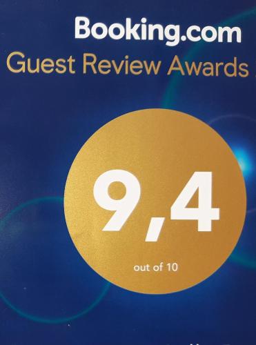 a sign that reads quest review awards with a gold circle at Office des bons enfants in Huy