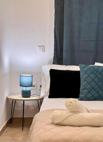a bed with a blue lamp on a table at Iras in Samos
