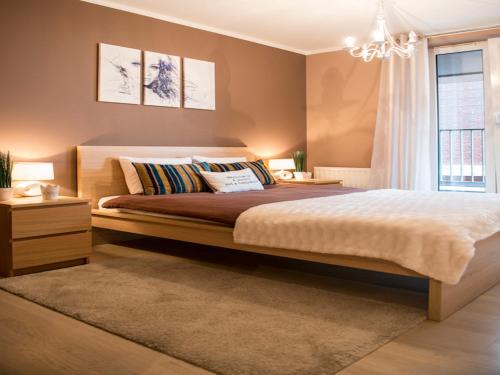 - une chambre avec un grand lit et un lustre dans l'établissement Apartament Nad Wisłą, à Cracovie