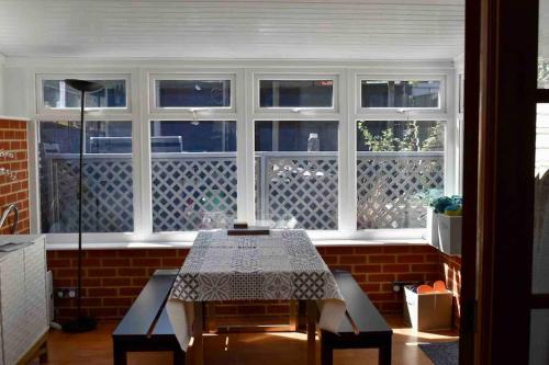 a dining room with a table in front of a window at Amazing seaside home 5mins from beach with HOT TUB in Broadstairs