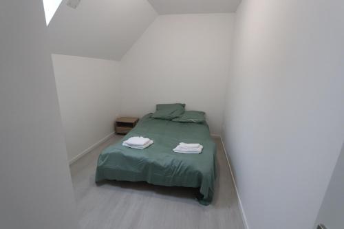a bedroom with a green bed in a white room at Homeday FERME KLEIN in Haguenau