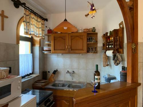 a kitchen with a sink and a stove top oven at Bolla Nyaralóház in Hegyhátszentjakab