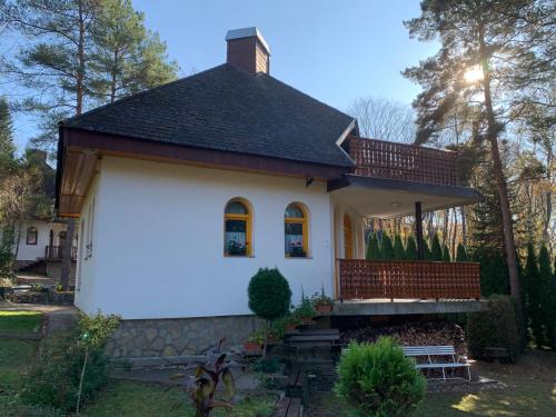 a small white house with a brown roof at Bolla Nyaralóház in Hegyhátszentjakab