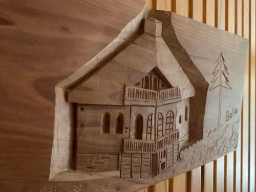 a drawing of a house on a wooden wall at Bolla Nyaralóház in Hegyhátszentjakab