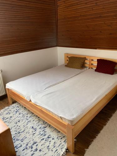 a bedroom with a bed with white sheets on it at Bolla Nyaralóház in Hegyhátszentjakab
