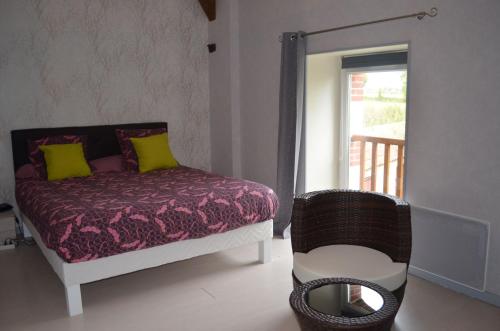 a bedroom with a bed and a chair and a window at Logis de Chezelles in Sidiailles
