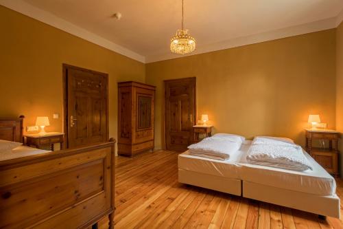 a bedroom with two beds and a chandelier at Hotel Lago di Braies in Braies