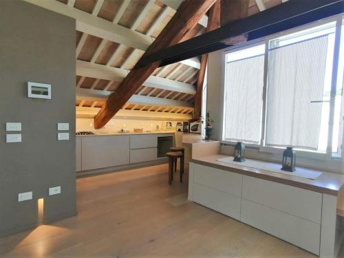 a large kitchen with white counters and a large window at CasaDei Sweet Home Design & Relax - Beach Parking in Cervia