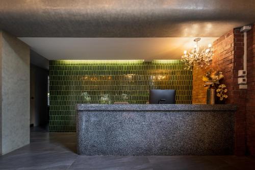 vestíbulo con recepción con azulejos verdes en fyn park hotel, en Makkasan