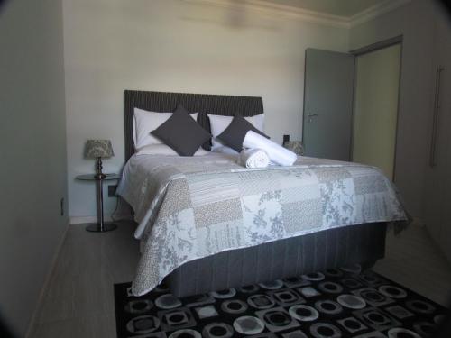 a bedroom with a bed with a blanket and pillows at 210 at Ocean in Cape Town