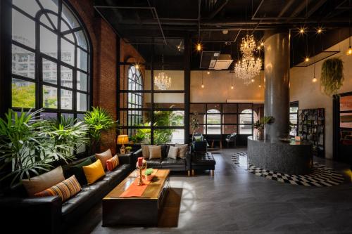a lobby with couches and plants in a building at fyn park hotel in Makkasan