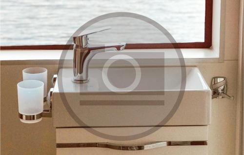 lavabo con grifo y ventana en 1 Bedroom Stunning Ship In Havelsee en Buchholz