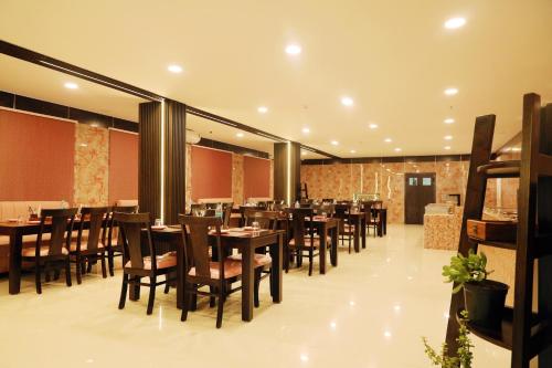 a dining room with wooden tables and chairs at RV STAY INN in Yelahanka