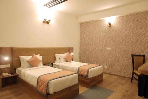 una habitación de hotel con dos camas en una habitación en RV STAY INN, en Yelahanka