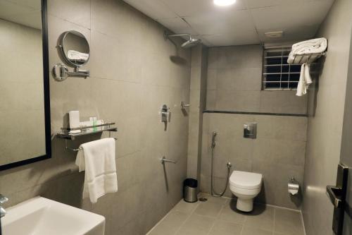 e bagno con doccia, servizi igienici e lavandino. di RV STAY INN a Yelahanka