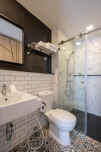 a bathroom with a toilet and a sink and a shower at fyn park hotel in Makkasan