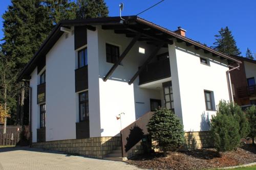 a white house with a black roof at Pension Lenka 2 in Harrachov