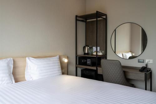a hotel room with a bed and a mirror at fyn park hotel in Makkasan