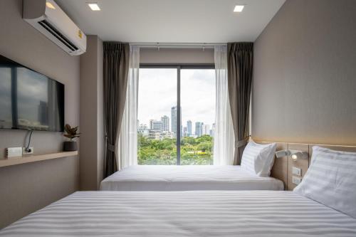 um quarto de hotel com duas camas e uma janela em fyn park hotel em Makkasan