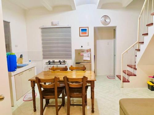 a kitchen with a wooden table and chairs at Awesome 2 bedrooms, living & dining area in General Trias