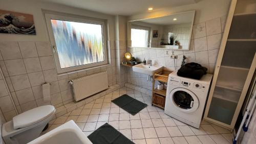 a bathroom with a washing machine and a sink at Schöne Wohnung mit Blick ins Grüne Messenah Exhibition apartment in Sehnde