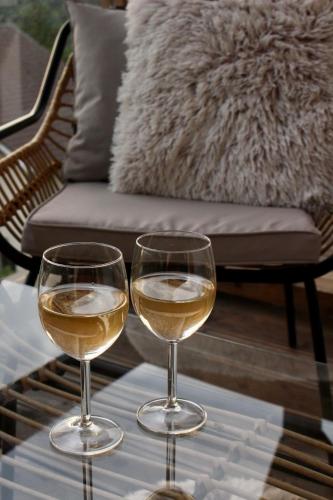 two glasses of white wine sitting on a table at Apartamenty Larice - balia lub sauna sesja gratis ten weekend, morsowanie w basenie in Świeradów-Zdrój