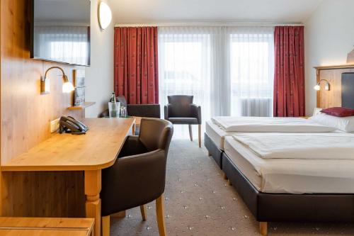 ein Hotelzimmer mit 2 Betten und einem Schreibtisch in der Unterkunft Hotel Wolfringmühle in Fensterbach