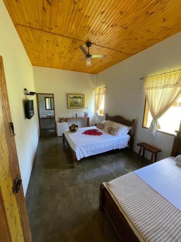sypialnia z 2 łóżkami i drewnianym sufitem w obiekcie Pousada Vale dos Diamantes w mieście Vargem Bonita