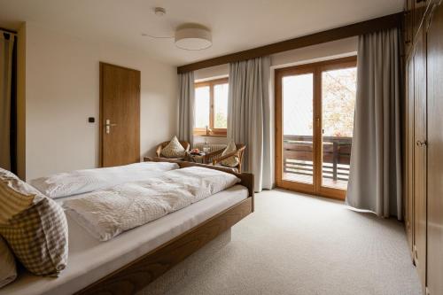 een slaapkamer met een bed en een groot raam bij Gästehaus Dauser in Obermaiselstein