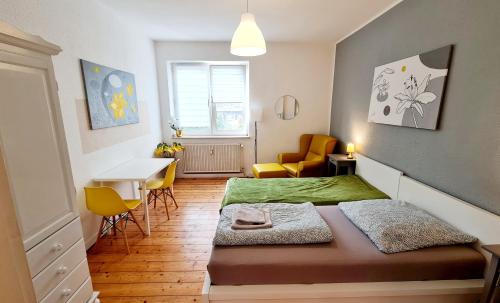 een slaapkamer met een bed en een tafel en stoelen bij ELENA flat LILIE, Oberhausen Zentrum CentrO Westfield in Oberhausen