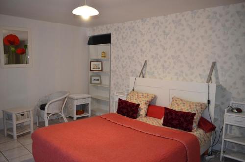 a bedroom with a bed with a red blanket at Logis de Chezelles in Sidiailles