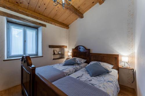 two twin beds in a room with wooden ceilings at House Grandići 1852 in Grandići