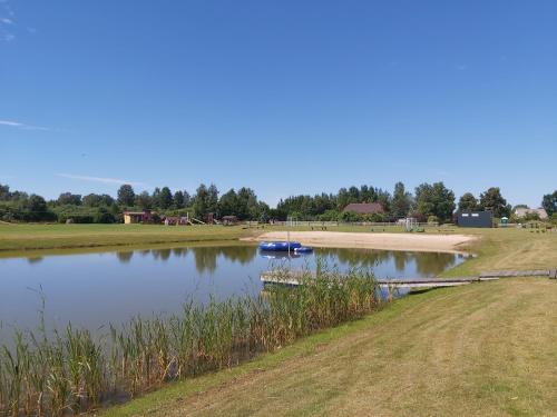 a blue boat sitting in the middle of a lake at Guest House Podnieki in Ventspils