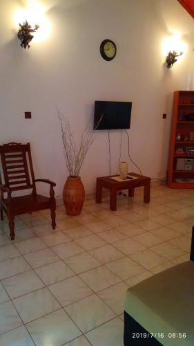 - un salon avec une télévision, une chaise et une table dans l'établissement Ceylon Travel and Stay Lodge, à Battaramulla