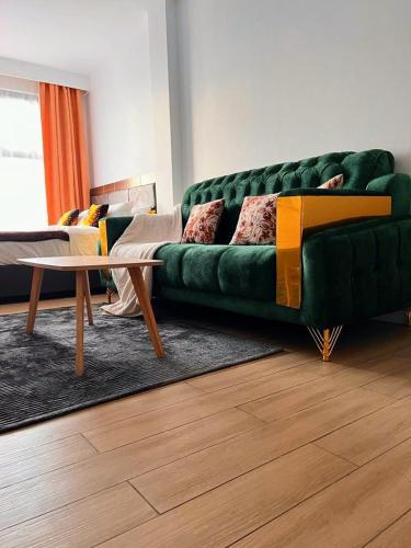 a living room with a green couch and a table at Avana studio in Nairobi