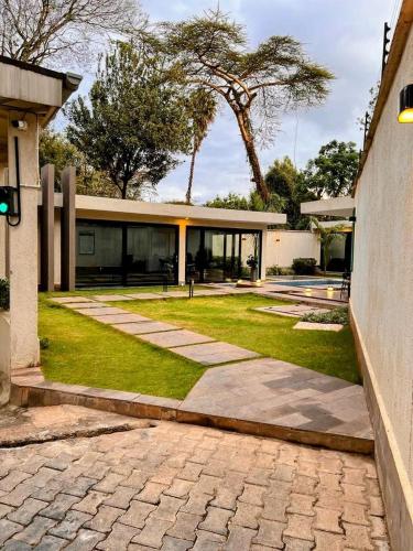 a house with a grass yard and a building at Avana studio in Nairobi