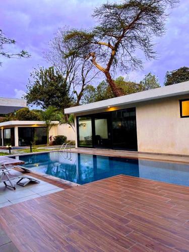 a swimming pool in front of a house at Avana studio in Nairobi