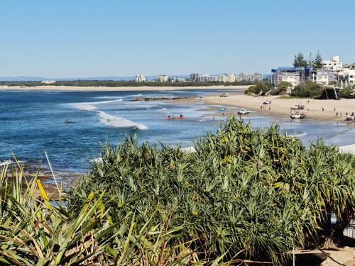 a beach with a bunch of people in the water at Little Mountain Retreat in Caloundra